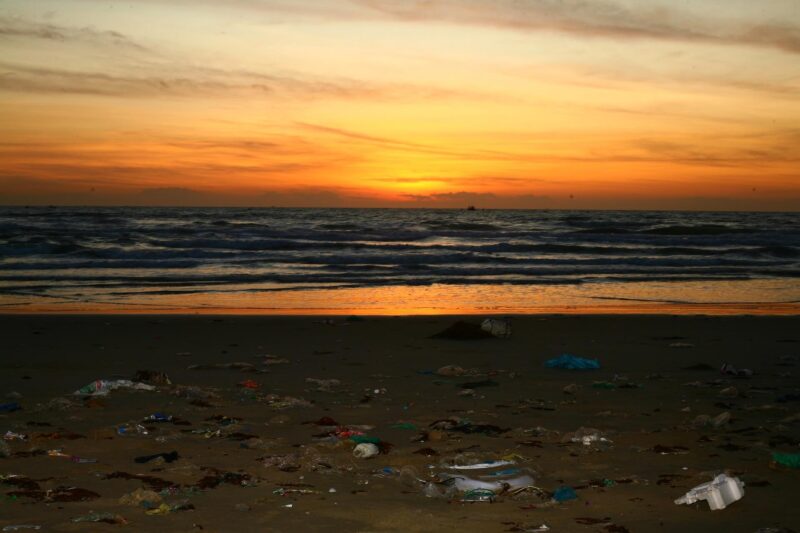 夕陽下充斥著海洋垃圾的沙灘